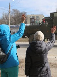 Lidé v krymském městě Armjansk mávají ruskému armádnímu vozidlu