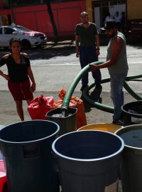 Lidé plní kbelíky vodou z cisterny ve čtvrti Azcapotzalco