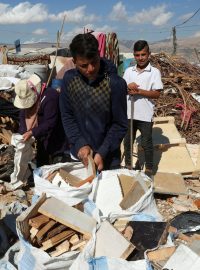 Syrští uprchlíci plní pytle odpadovým dřevem, které prodávají na táboráky v provizorním táboře v libanonském údolí Bikáa