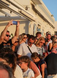 Turisté pozorující západ slunce na ostrově Santorini