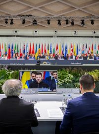 Ukrajinský prezident Volodymyr Zelenskyj na monitorech při své účasti na plenárním zasedání summitu