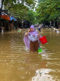 Žena se brodí zaplavenou ulicí ve městě Thai Nguyen ve Vietnamu. Kvůli supertajfunu Yagi zemřelo ve Vietnamu přes 140 lidí