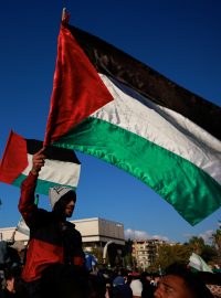 Lidé mávají palestinskou vlajkou a vlajkou přijatou novými syrskými vládci, jak lidé oslavují poté, co bojovníci vládnoucího syrského orgánu svrhli syrského Bašára Asada, ve starém městě Damašku, Sýrie, 13. prosince 2024