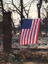 Kdosi se vrátil k troskám svého domu a na znamení, že není pokořený, vyvěsil nad spáleništěm americké vlajky.