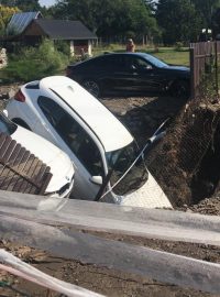 Do kaverny vzniklé po prasklém přivaděči vody v Dolních Počernicích se propadly dva automobily.