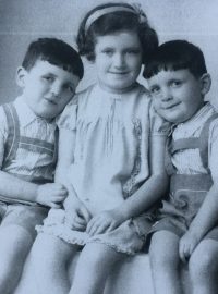 Dvojčata Jiří a Josef Fišerovi se svou starší sestrou Věrou. Snímek pochází z roku 1938. Věra později zahynula v plynové komoře, stejně jako matka dětí. Věře bylo tehdy 10 let.