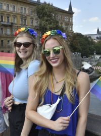 Tradiční duhové vlajky letos kvůli horku doplnily duhové vějíře a kvůli koronaviru také duhové roušky.