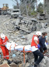 Zdravotníci Libanonského červeného kříže ve vesnici Ajtú na severu Libanonu vynášejí tělo z trosek domu po izraelském vzdušném úderu (14. října 2024)