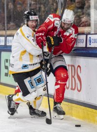 Hokejista Kärpät Oulu Patrik Virta v souboji o puk s pardubickým Michalem Houdkem v zápase Spengler Cupu