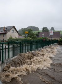 Říčka Bělá v Písečné začíná přetékat přes most