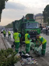 Po večerních oslavách zůstaly na Champs-Élysées tuny odpadků. S košťaty, lopatami a fukary se na ně vrhli uklízeči v zelenožlutých uniformách.