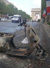 Kromě všudypřítomných odpadků připomínají noční bujaré oslavy na Champs-Élysées také rozbité výlohy nebo jeden totálně ohořelý moped.