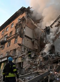 Záchranáři pracující v troskách budovy zničené ruským raketovým útokem